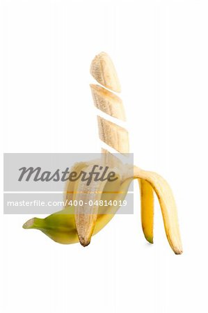 Pieces of banana floating in midair on white background