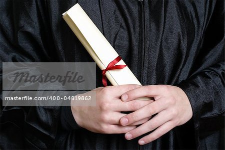 A macro shot of a graduating student holding their diploma proudly.