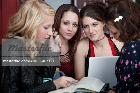 Four attractive girls busy with a school project