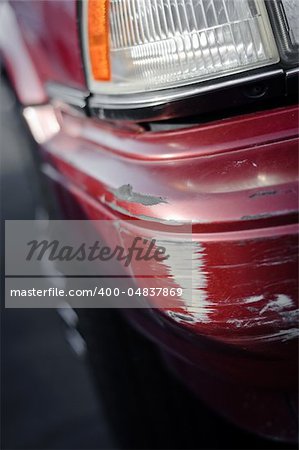 Scratch on a bumper of a red car
