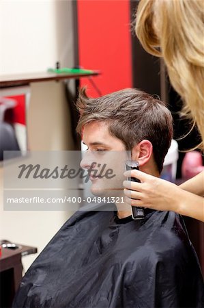 Young caucasian man being shaved in a hairdressing salon