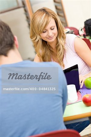 Serious couple of students working together in the cafeteria of their university