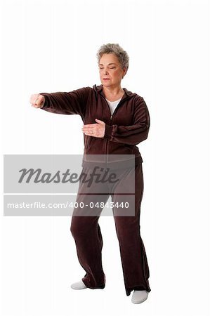 Beautiful Senior woman doing Tai Chi punching exercise to keep her joints flexible, isolated.
