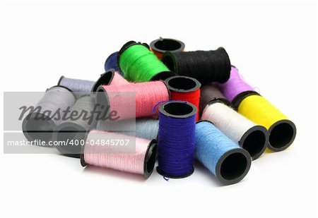 lot of colored thread spools on white