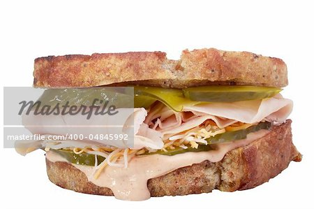 Sandwich with meat, pickles, and cheese isolated on a white background.