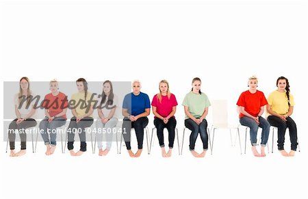 Group of women sitting on chairs and one empty chair