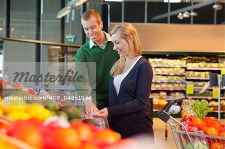 Man and woman looking at products and smiling in shopping store