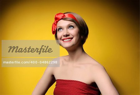 Close-up portrait of smiling beautiful young girl in retro style. Isolated on yellow background