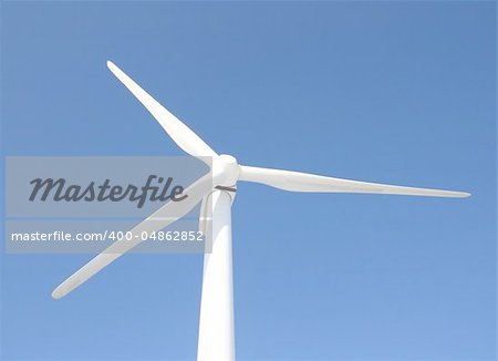 View of single windmill generating electricity against blue sky