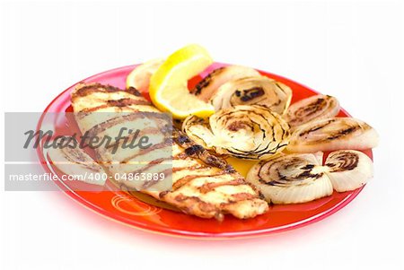 Grilled chicken breasts with onion and lemon in a plate