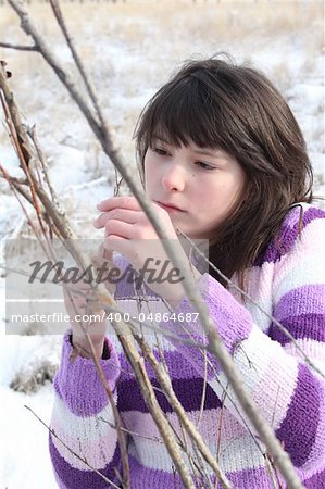 Young brunette teen playing in the field after the snowfall