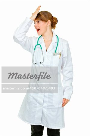 Surprised medical doctor woman striking her forehead  isolated on white