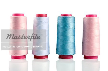 Some plastic spools with multicoloured threads isolated on white