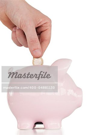 Hand inserting a coin in a pink piggy bank against a white background.