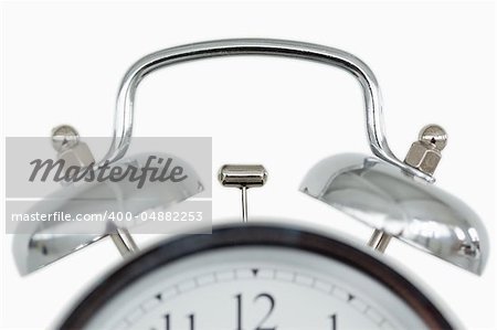 Close up of an old fashioned alarm clock against a white background