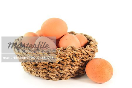 Fresh raw eggs in a basket on a white background