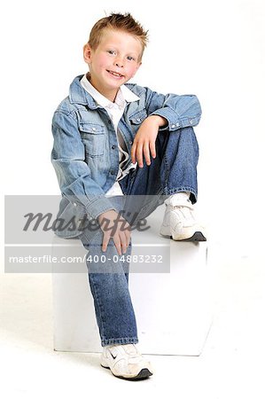 young attractive boy wearing a blue jean jacket sitting and smiling