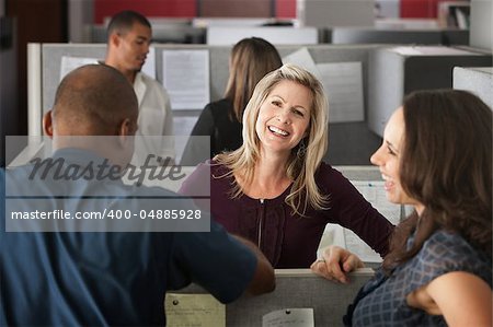 Office workers laugh at a joke shared by colleague