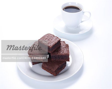 Chocolate brownies on white plate and cup of coffee