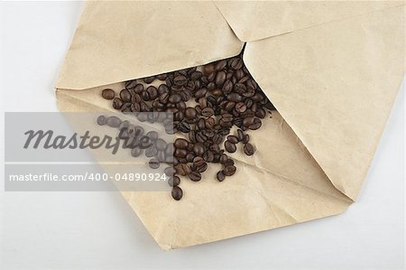 Coffee beans scattered in opened envelope