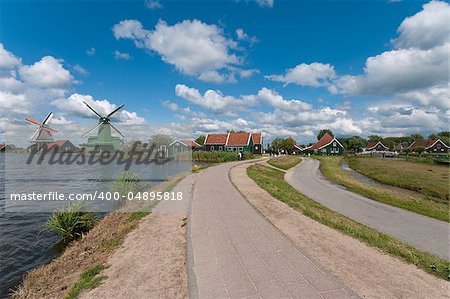 road along the water with the famous windmills of the zaanse schans