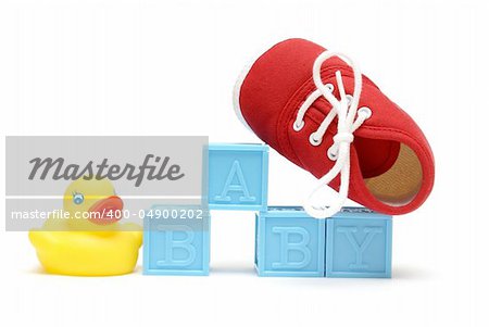 The word baby is isolated on white with a rubber ducky and a red shoe.