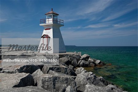 A small lighthouse warns of a rough shoreline.