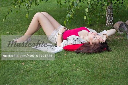 Woman lying on her back, resting with book.