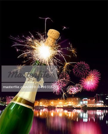 Champagne bottle cork popping with sparkling New Year fireworks