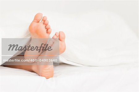 Feet in a bed against a white background