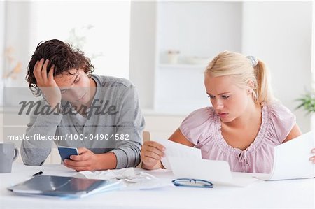 Couple in despair while doing accounts in the living room