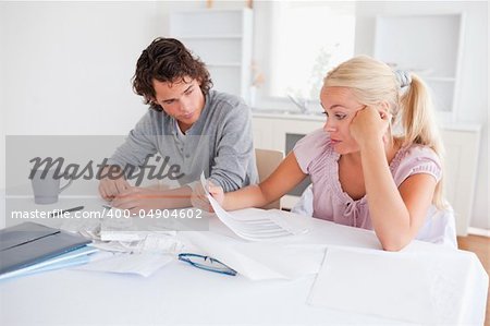 Stressed couple doing accounts in their living room