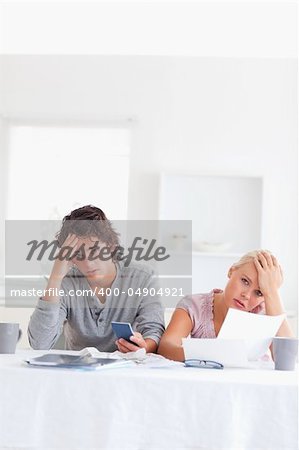 Worn out couple calculating their expenses in the living room