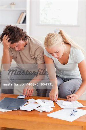 Despaired couple calculating their expenses in the living room