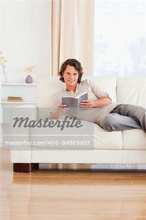 Portrait of a man holding a book in his living room