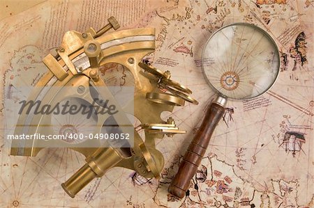Antique sextant and magnifier glass on old map