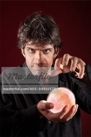 Caucasian fortuneteller holds glowing crystal ball