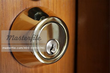 A stock photo of a keyhole on wood door