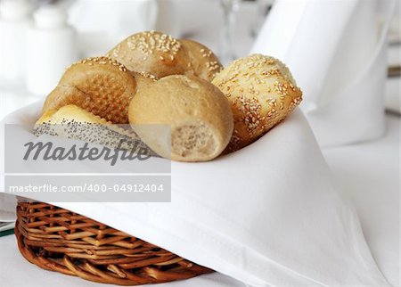 wooden basket covered with white cloth full of small bread