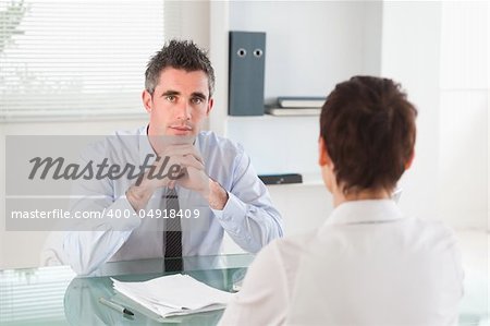 Serious manager interviewing a female applicant in his office