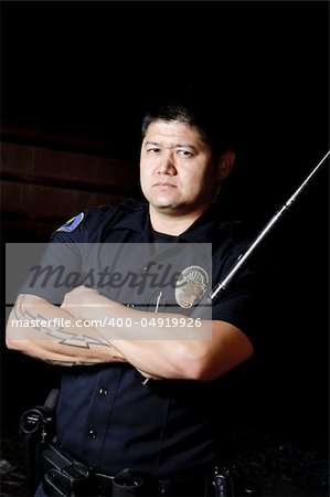 a police officer holding his baton in the night.