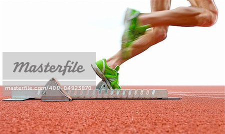 Action packed image of an athlete leaving the starting blocks for a sprint run on a track