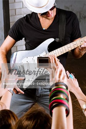 Rock guitarist playing in front of a cheering crowd.