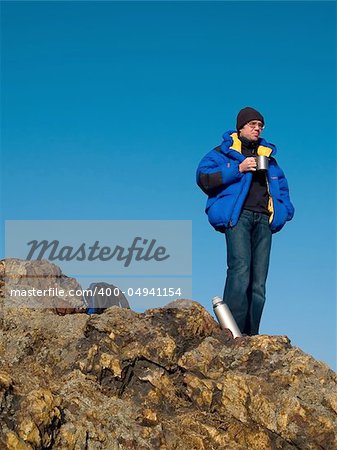 man thinking on the mountain top with blue sky