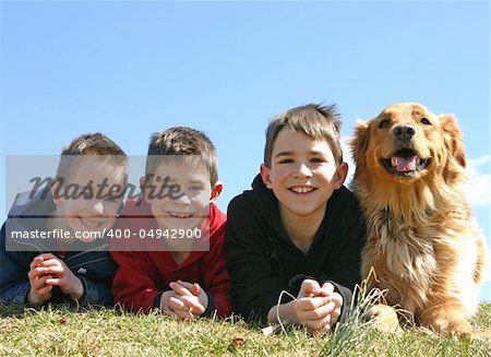 A dog smiling with three young boys