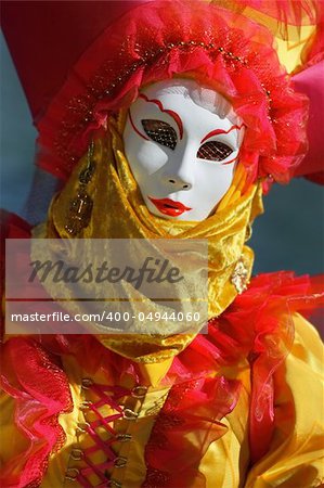 Model dressed in a costume with a decorated venetian mask in bright colors.