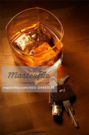 Whiskey in light pool on brown table with car keys