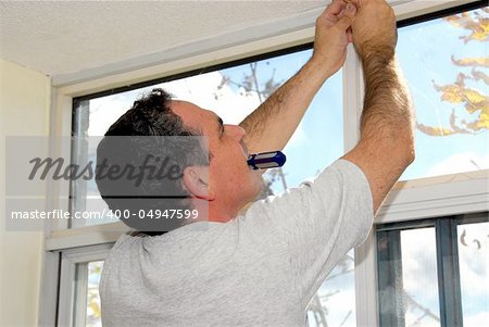 Man installing window blinds in a house