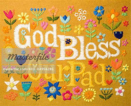 Vintage needlepoint wall hanging of colorful flowers surrounding the phrase God Bless Our Pad.