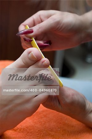 beautician making pedicure to the young woman. Hands close-up, soft-focused